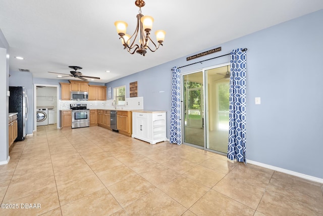 5 Cantilever Ct, Ormond Beach, FL 32174 - kitchen featuring appliances with stainless steel finishes, washer / dryer, a chandelier, a ceiling fan, and light countertops