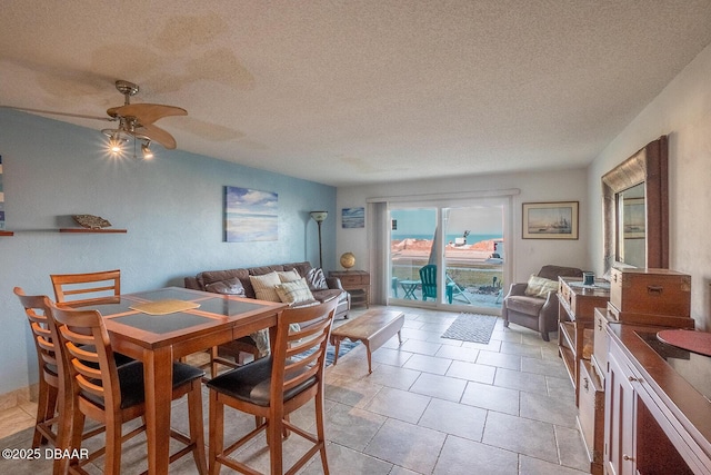 dining area with ceiling fan, a textured ceiling, and light tile patterned flooring