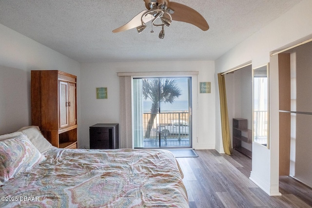 bedroom with hardwood / wood-style floors, ceiling fan, access to outside, and a textured ceiling