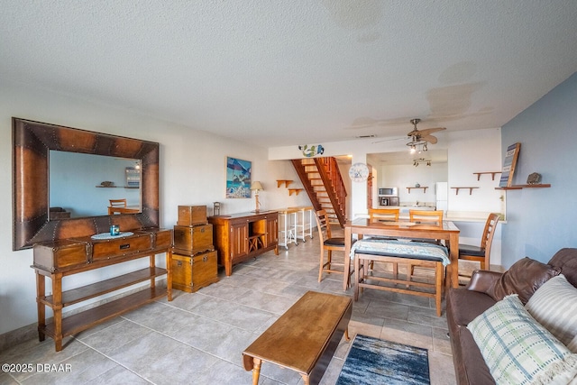 living room with a textured ceiling and ceiling fan