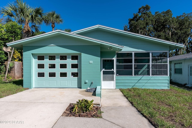 view of front facade featuring a garage and a sunroom