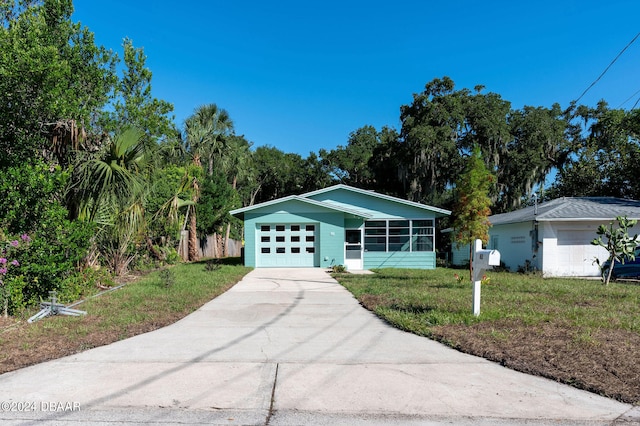 ranch-style house with a garage and a front lawn