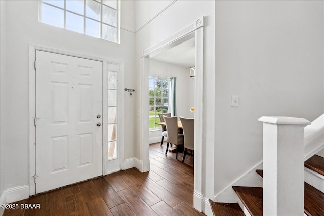 entryway with stairway, baseboards, and dark wood-style flooring