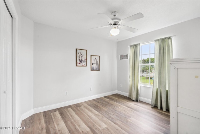 unfurnished room featuring a ceiling fan, baseboards, and wood finished floors
