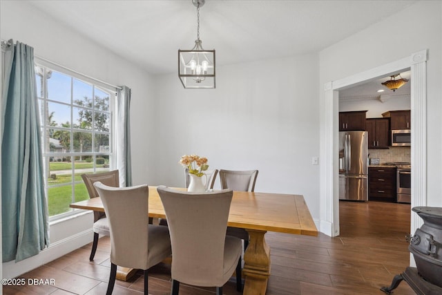 dining room featuring dark wood-style flooring, baseboards, and a chandelier