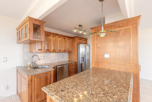 kitchen featuring light stone countertops, appliances with stainless steel finishes, backsplash, sink, and pendant lighting