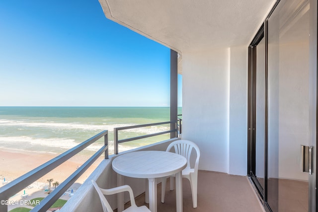 balcony with a water view and a beach view