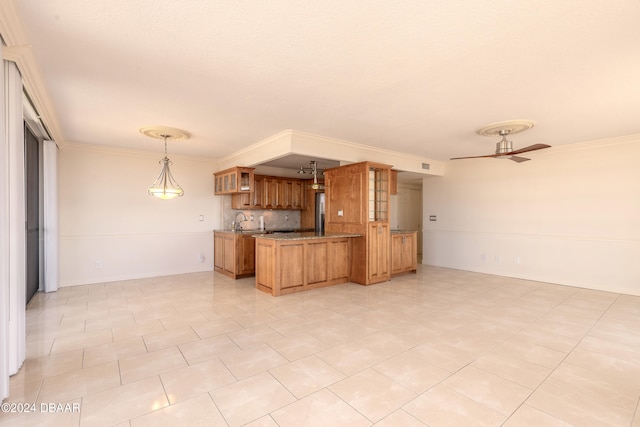 kitchen featuring backsplash, ornamental molding, ceiling fan, sink, and hanging light fixtures