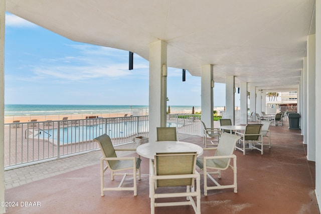 view of patio with a beach view and a water view