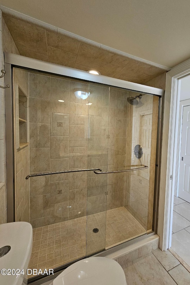 bathroom with tile patterned flooring and a shower with door