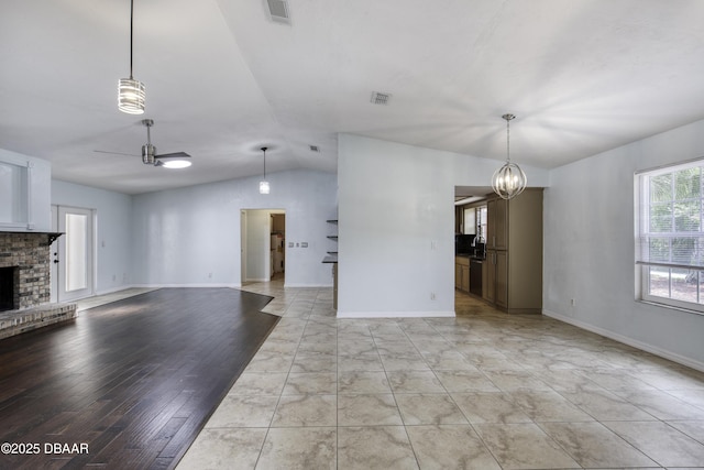 952 Northbrook Dr, Ormond Beach, FL 32174 - unfurnished living room with vaulted ceiling, ceiling fan, a brick fireplace, a chandelier, and baseboards