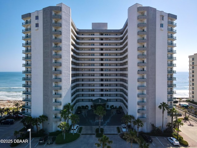 view of building exterior with a beach view and a water view