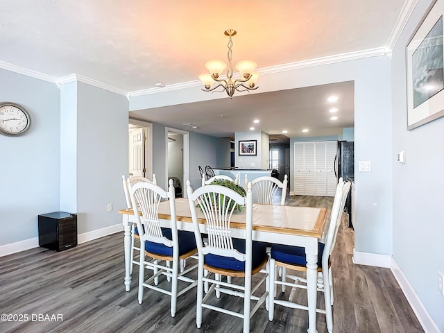 dining space featuring crown molding, dark hardwood / wood-style floors, and an inviting chandelier