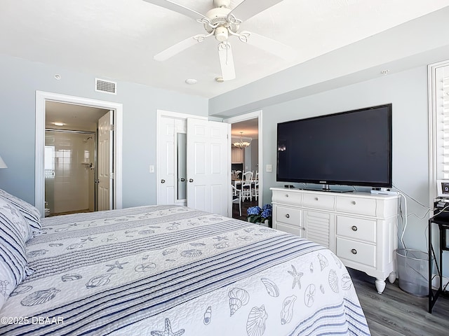 bedroom featuring ceiling fan with notable chandelier, dark hardwood / wood-style flooring, and ensuite bath