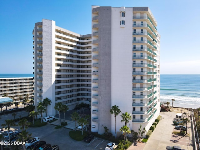 view of property with a water view and a beach view