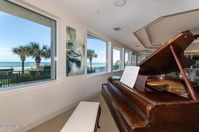 misc room with a water view and carpet floors