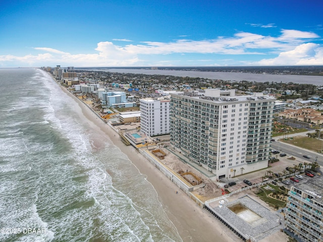 birds eye view of property with a water view and a beach view