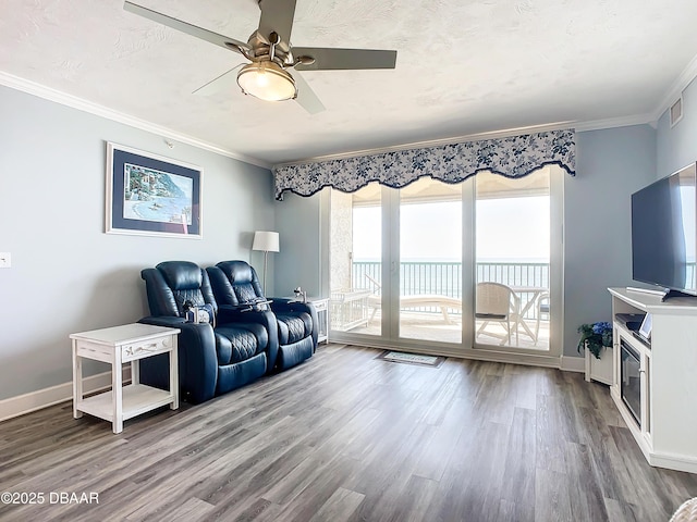 living room with hardwood / wood-style floors, crown molding, a textured ceiling, and ceiling fan