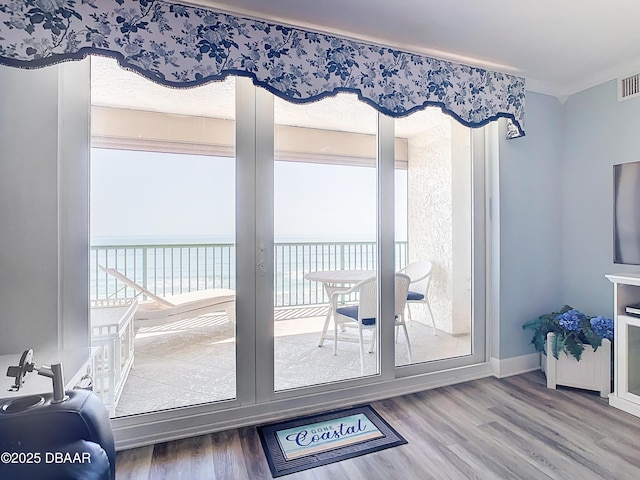 doorway to outside featuring a water view, hardwood / wood-style floors, and a textured ceiling