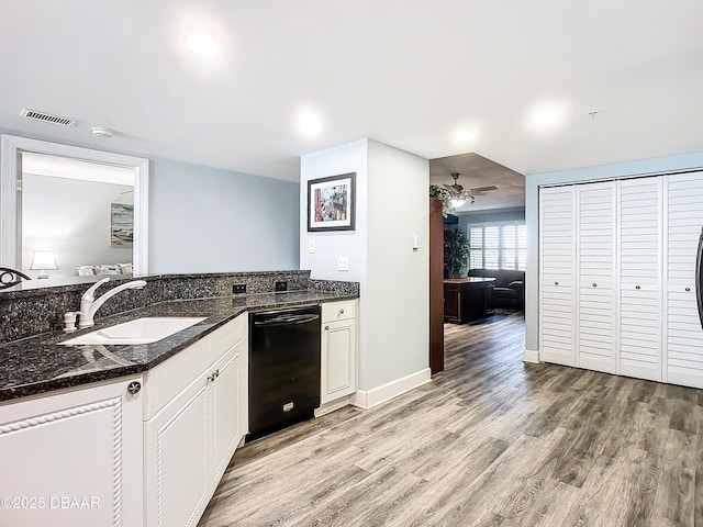 kitchen featuring sink, dishwasher, light hardwood / wood-style floors, white cabinets, and dark stone counters