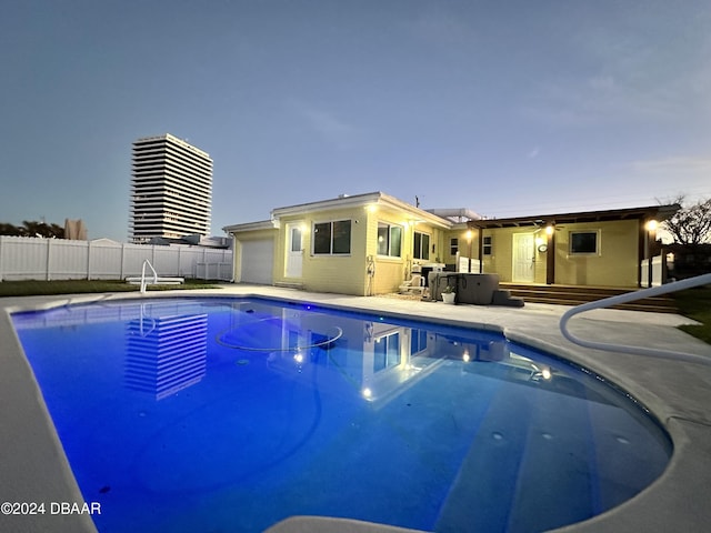 pool at dusk featuring a patio area