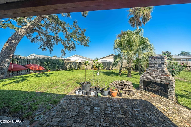 25 Laughing Gull Ln, Edgewater, FL 32141 - fenced backyard featuring exterior fireplace and a patio area