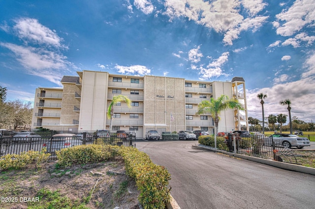 view of property featuring uncovered parking and fence