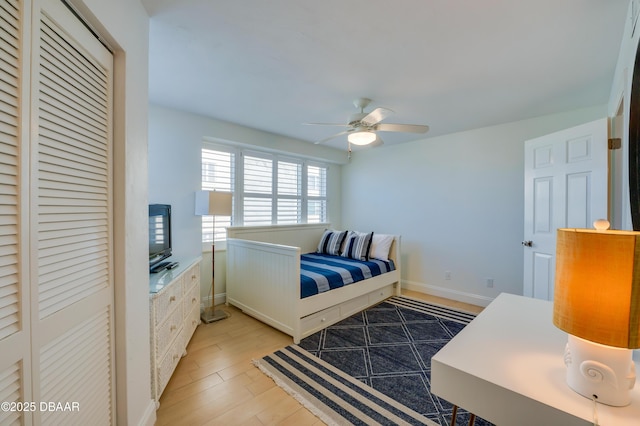 bedroom featuring a closet, a ceiling fan, light wood-type flooring, and baseboards