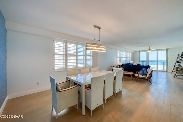 dining space with light wood finished floors, baseboards, and ceiling fan