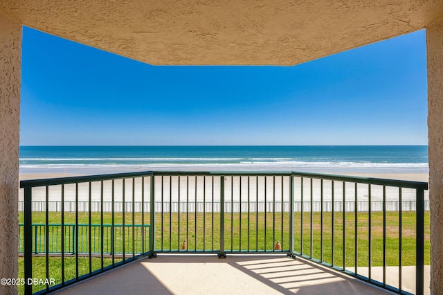 balcony featuring a water view and a beach view