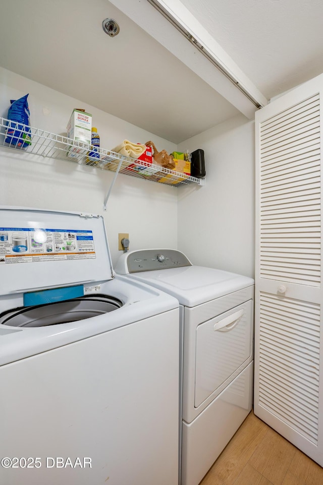 washroom with laundry area, light wood-style floors, and washer and clothes dryer