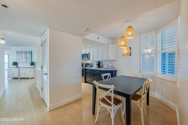 dining space featuring visible vents, baseboards, and light wood-style floors