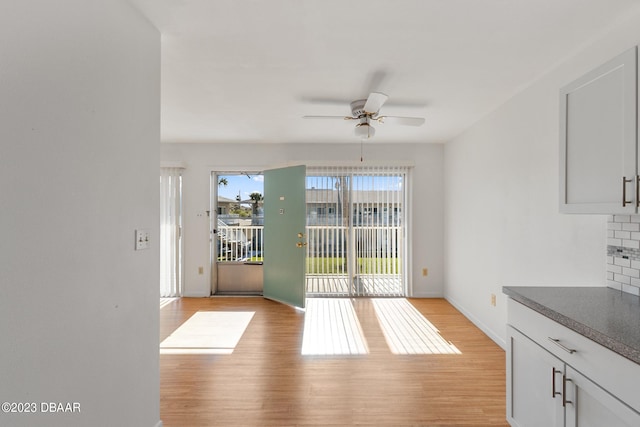 doorway with ceiling fan and light hardwood / wood-style floors