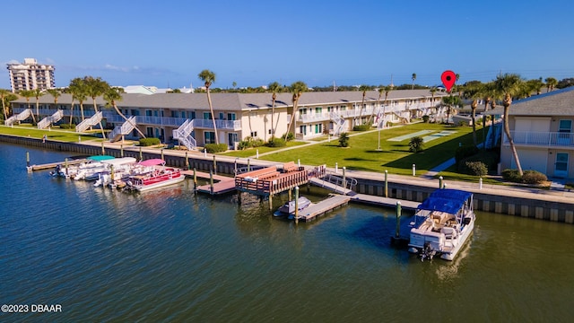 view of dock with a water view and a yard