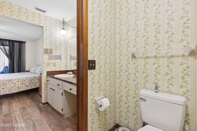 42 Soco Trl, Ormond Beach, FL 32174 - bathroom with wood finished floors, wallpapered walls, vanity, toilet, and ensuite bath
