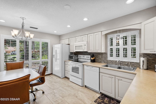 42 Soco Trl, Ormond Beach, FL 32174 - kitchen featuring white appliances, a sink, decorative backsplash, a chandelier, and light countertops