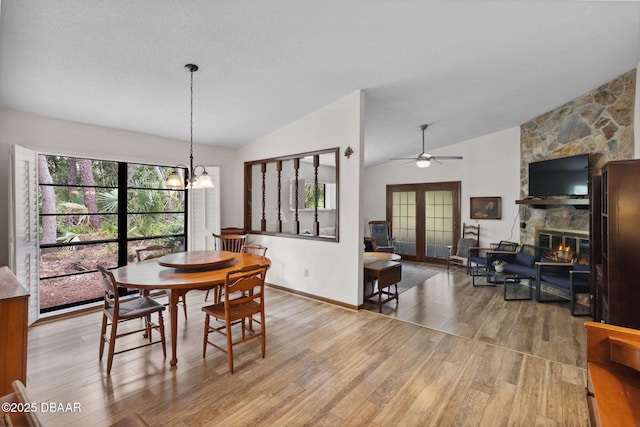 42 Soco Trl, Ormond Beach, FL 32174 - dining space featuring lofted ceiling, wood finished floors, ceiling fan, a fireplace, and a chandelier