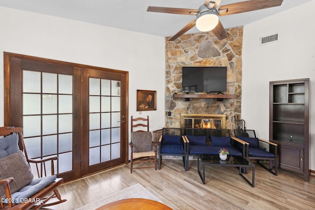 42 Soco Trl, Ormond Beach, FL 32174 - living room with wood finished floors, a ceiling fan, and a stone fireplace