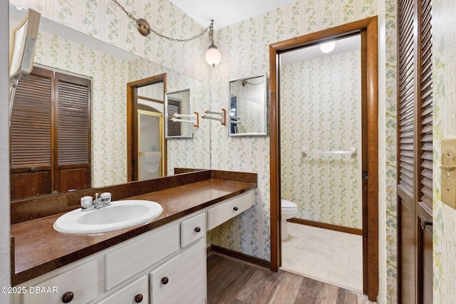 42 Soco Trl, Ormond Beach, FL 32174 - full bath with toilet, wallpapered walls, vanity, wood finished floors, and a closet