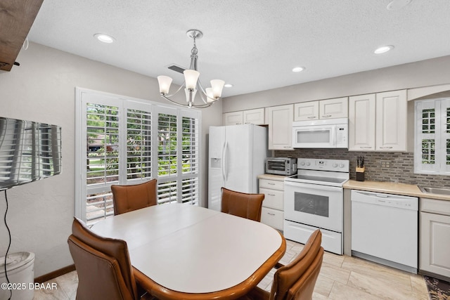 42 Soco Trl, Ormond Beach, FL 32174 - kitchen with white appliances, a chandelier, light countertops, tasteful backsplash, and decorative light fixtures