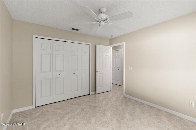 3 Slow Stream Way, Ormond Beach, FL 32174 - unfurnished bedroom featuring a closet, light tile patterned flooring, a textured ceiling, and a ceiling fan