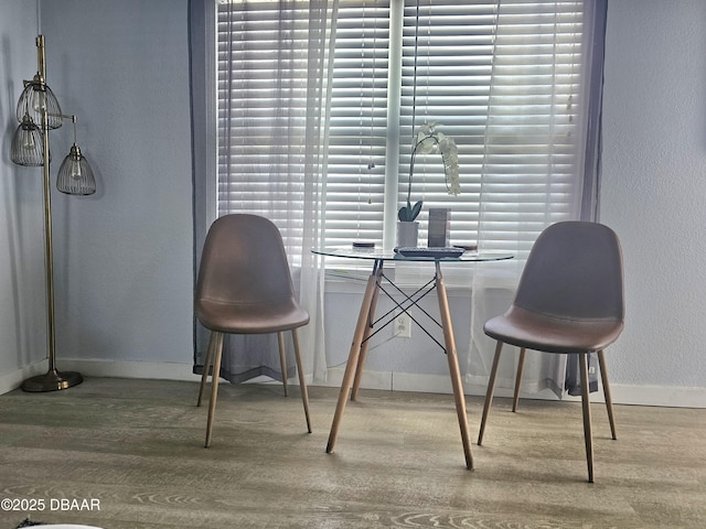 dining space with baseboards, a wealth of natural light, and wood finished floors