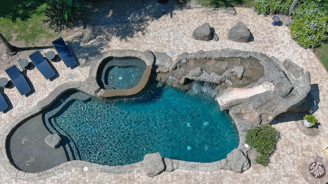 view of swimming pool featuring an in ground hot tub and a patio