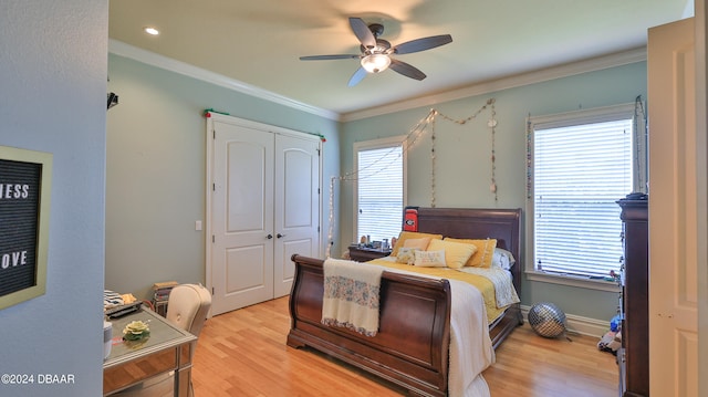 bedroom featuring a closet, multiple windows, ceiling fan, and light hardwood / wood-style flooring