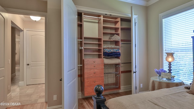 bedroom featuring crown molding and light hardwood / wood-style flooring