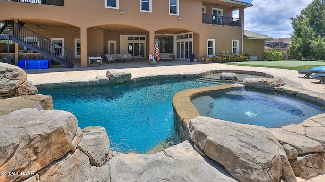 view of swimming pool featuring an in ground hot tub and a patio