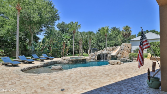 view of swimming pool with pool water feature, an in ground hot tub, and a patio