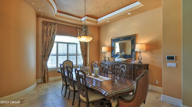 dining space with a raised ceiling and crown molding