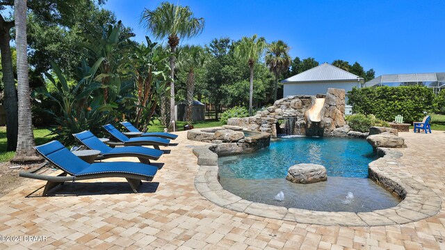 view of swimming pool with pool water feature and a patio area