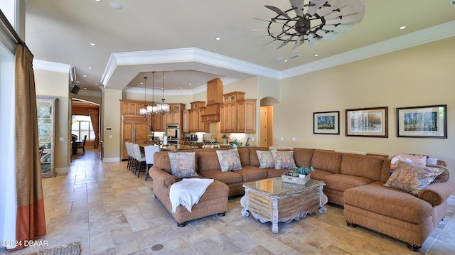 living room featuring ceiling fan with notable chandelier and ornamental molding